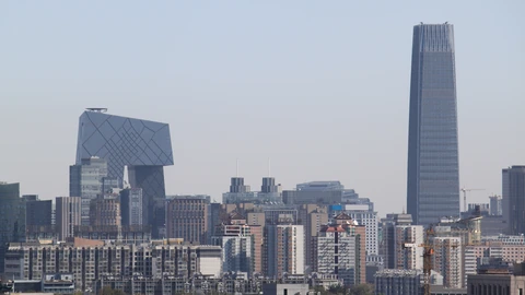 Distant Beijing CBD towers seen across tree-covered hills. No identifiable people appear.