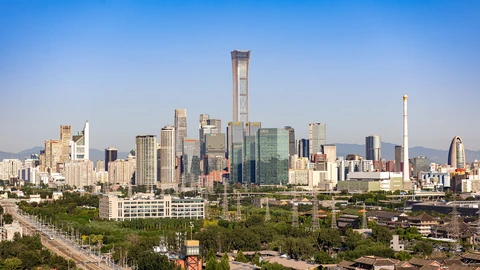 Beijing CBD high-rises in morning haze viewed from the southeast. No identifiable people appear.