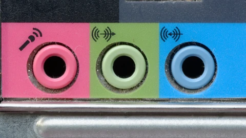 Close-up of three 3.5 mm computer jacks labeled for microphone, headphones, and line-in. No people appear.