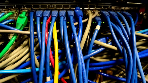 Close-up of an Ethernet switch with many RJ45 ports and status LEDs. No people appear.