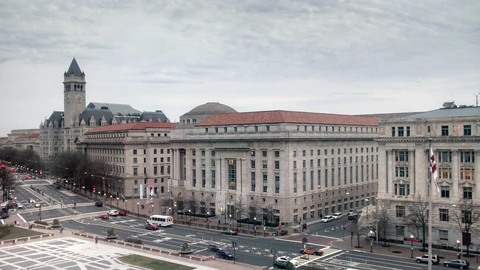 Federal Triangle buildings and Freedom Plaza in Washington, D.C., under a clear sky. No identifiable people appear.