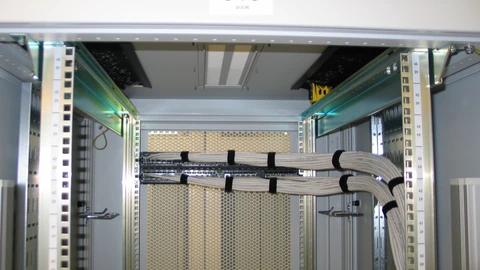 An empty equipment rack with two patch panels and dangling cables. No people appear.