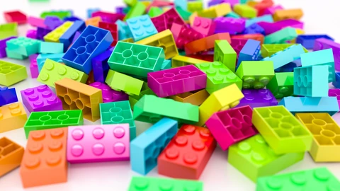 Close-up of LEGO bricks lying on a floor, with studs and colors filling the frame. No people appear.