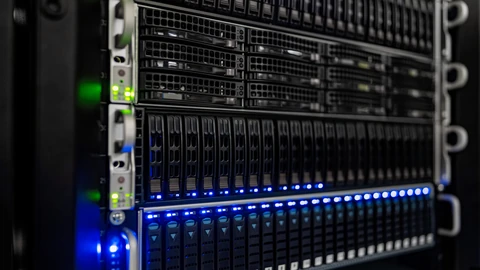 Close-up of rack-mounted servers with rows of drive bays and blue and green status lights.