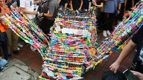 Several colorful paper origami cranes arranged on a surface. No people appear.
