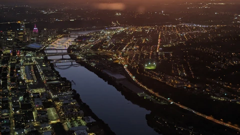 Downtown Pittsburgh buildings reflected in the Allegheny River at dusk. No identifiable people appear.