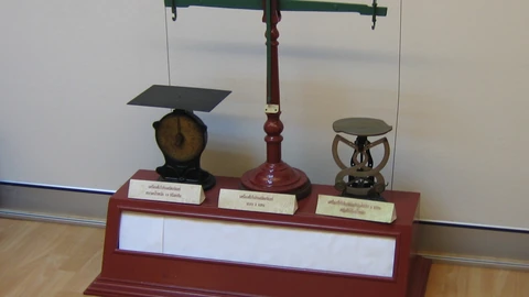 A metal postal scale on a surface. No people appear.