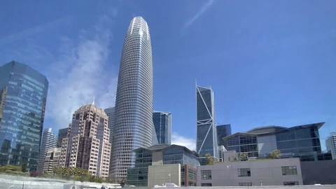 Salesforce Tower rising above San Francisco buildings under a clear sky. No identifiable people appear.