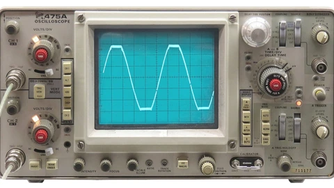 A Tektronix 475A analog oscilloscope with CRT screen and control knobs on a bench. No people appear.