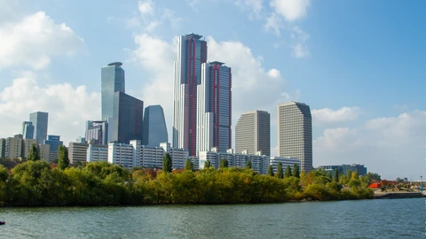 Yeouido skyscrapers along the Han River under autumn light. No identifiable people appear.