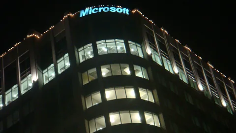 The Microsoft sign illuminated in blue at night on the Bravern Building 1 in Bellevue, Washington.