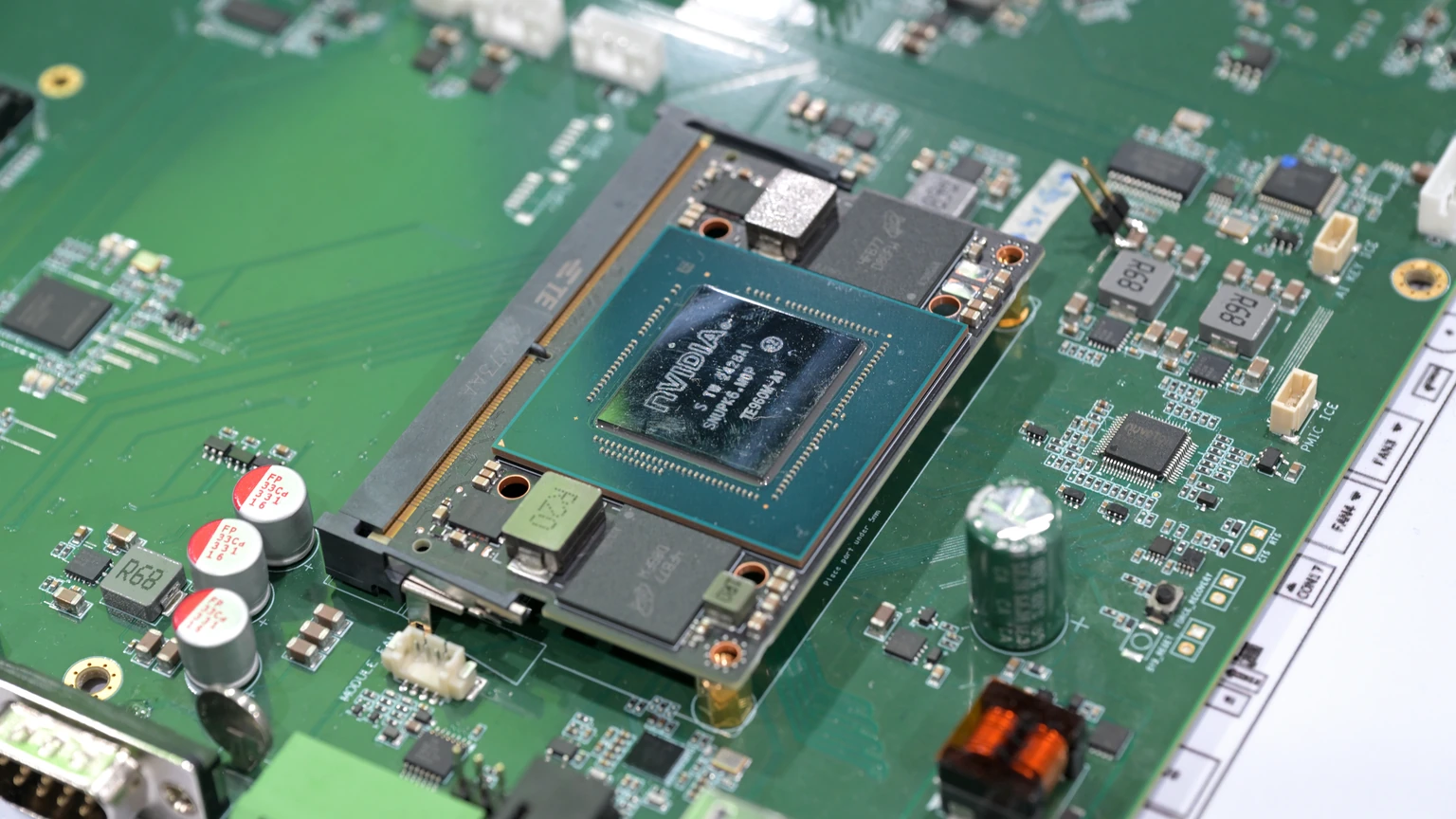 Close-up of an NVIDIA Jetson Orin NX module seated on a green motherboard, with the NVIDIA mark visible on the die.