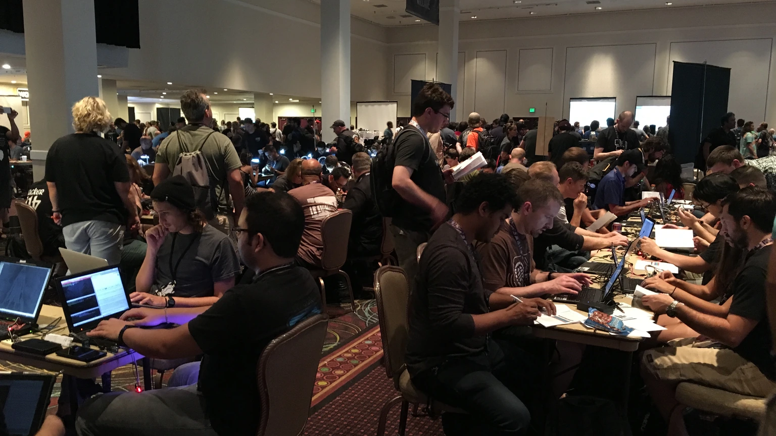 Rows of laptops and monitors on contest tables at the DEF CON 24 hacking conference.