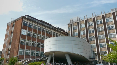 The brick Laboratory of Molecular Biology building in Cambridge under a blue sky.