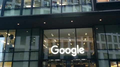 The glass entrance of a Google office at 6 Pancras Square in London, with a white Google logo above revolving doors.