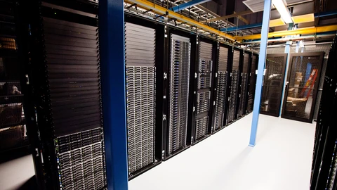 Close view of illuminated server racks and network equipment in a data center.