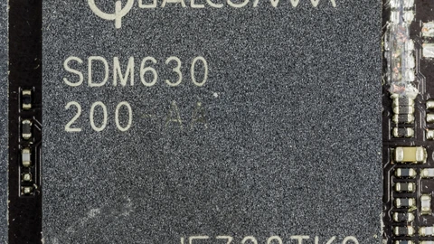 Close-up of a black Qualcomm SDM630 200-AA package on a phone board, with white part markings and no people in the frame.