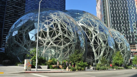 The Amazon Spheres glass conservatories beside Seattle office towers under a clear sky. No identifiable people appear.