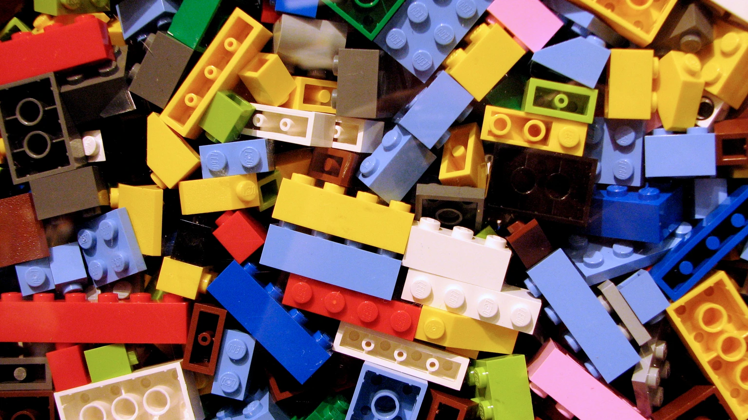 A dense pile of multicolored LEGO bricks filling the frame. No people appear.