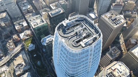 Aerial view of Salesforce Tower’s roof and surrounding San Francisco high-rises under haze. No identifiable people appear.