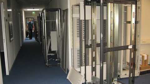An empty black 19-inch server rack with patch panels near the top and open mounting rails. No people appear.