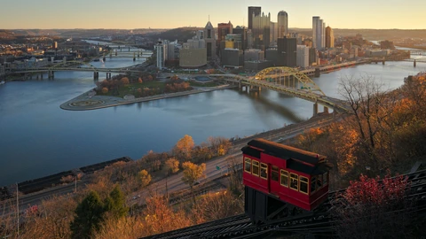 Downtown Pittsburgh skyline across the rivers in soft morning light. No identifiable people appear.