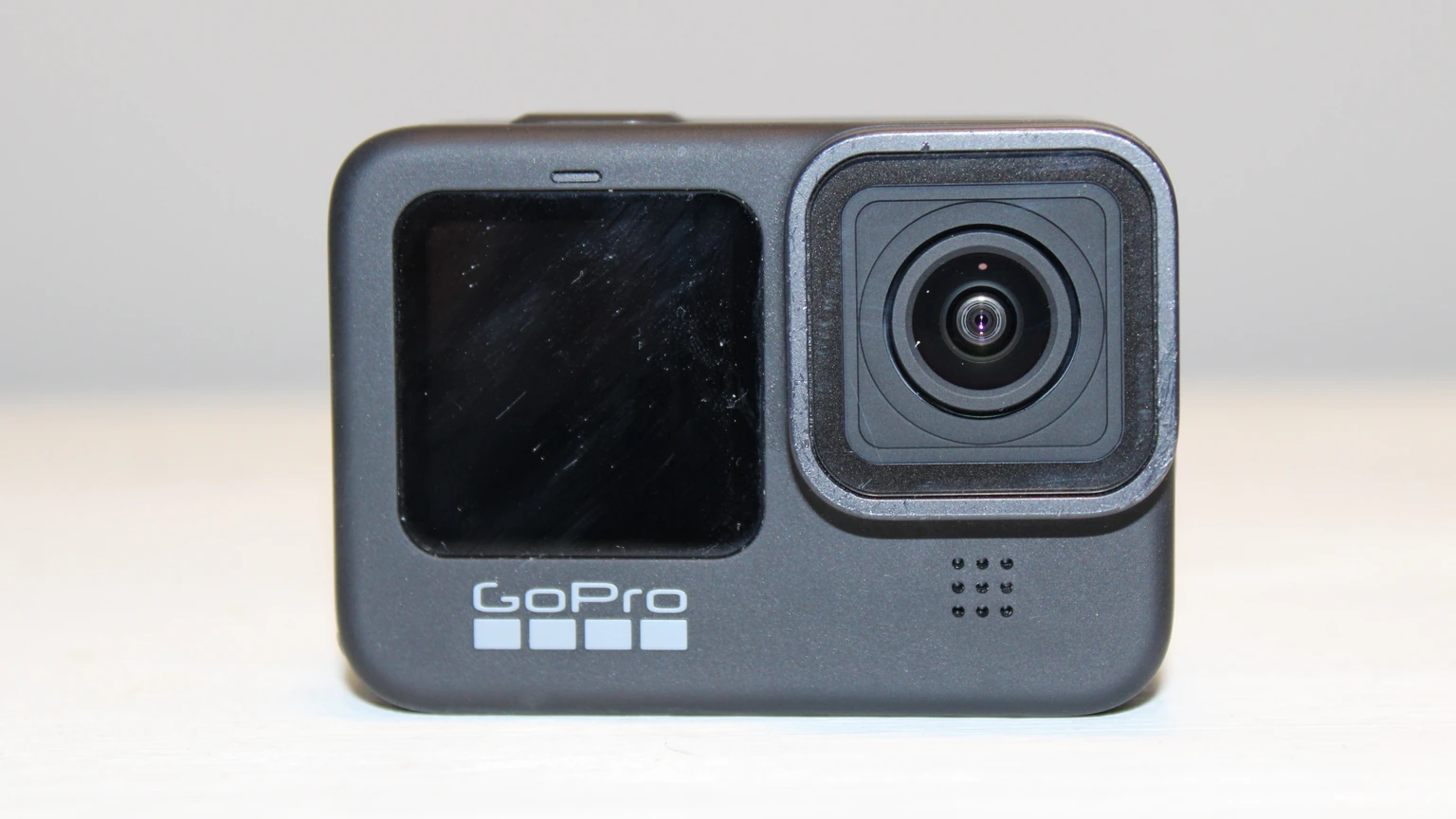 A black GoPro Hero 9 action camera facing the lens on a plain surface. No people appear.