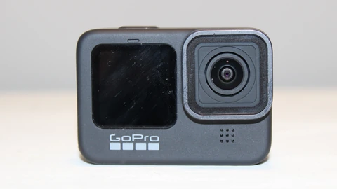 A black GoPro Hero 9 action camera facing the lens on a plain surface. No people appear.