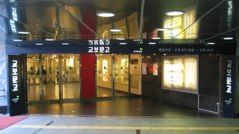 The entrance to Kyobo Book Centre's Gwanghwamun branch in Seoul, with glass doors under a dark sign showing the store's Korean name and the green KYOBO logo.