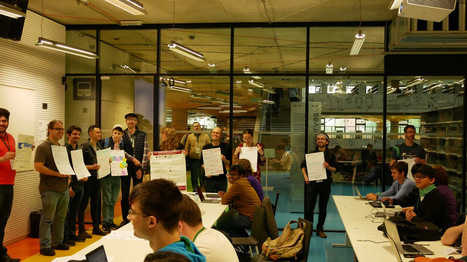 Hackathon participants comparing project ideas beside presentation boards.