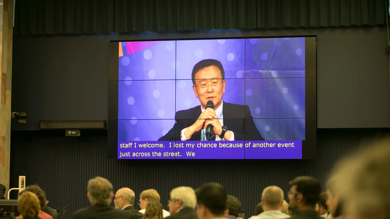 Chaesub Lee speaking into a microphone on a large conference screen.