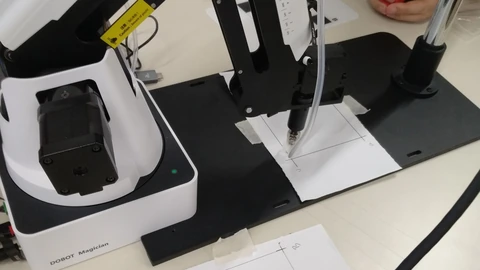 A small Dobot Magician robotic arm on a laboratory workstation.