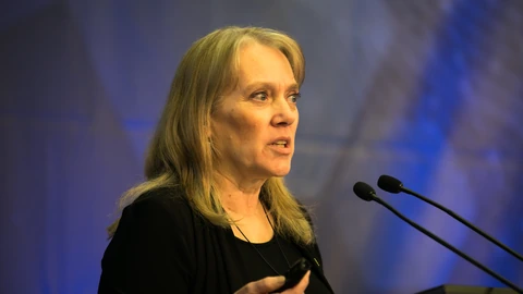 Vicki Hanson speaking into microphones onstage.