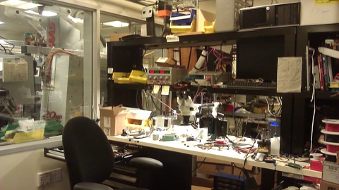 Electronics workbench with a microscope and soldering equipment.