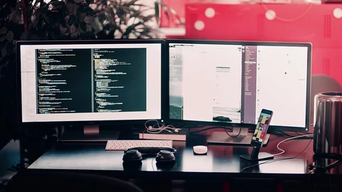 A coding workstation with multiple computer displays.