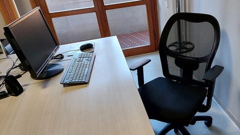 An unoccupied workstation with desk and computer equipment.