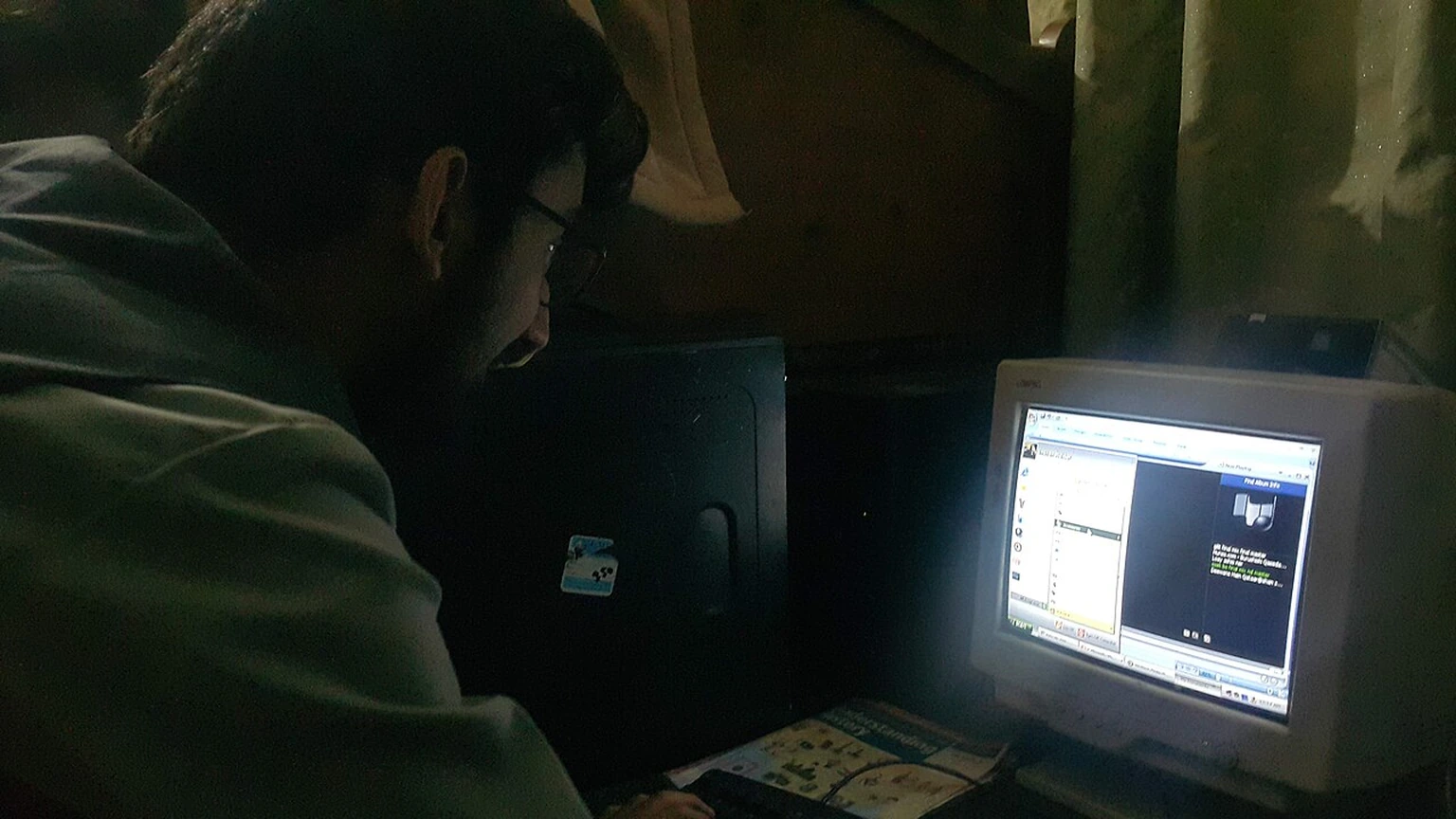 A person using a desktop tower computer with a Compaq CRT monitor.